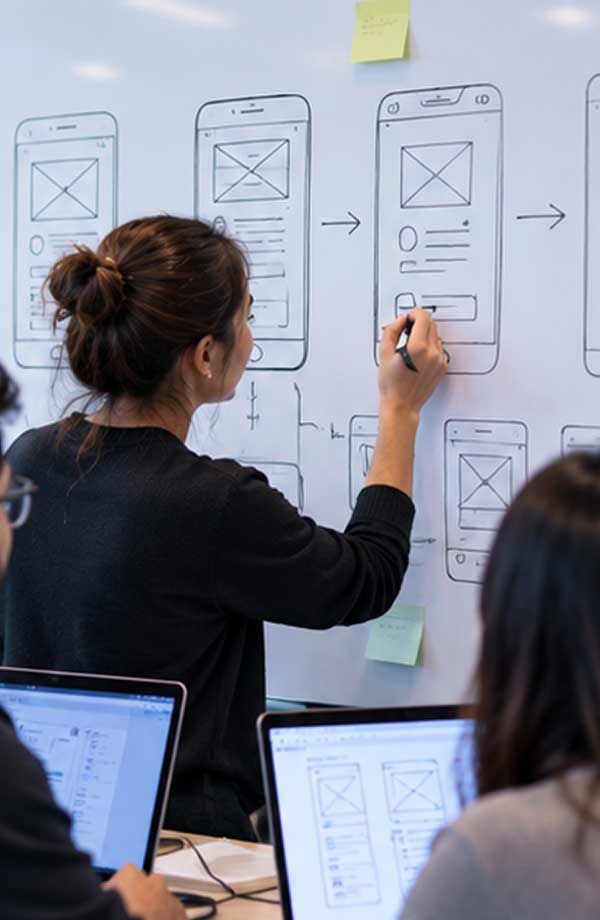 An engineer sketching a workflow on a whiteboard